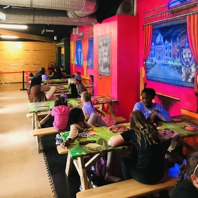 Menschen essen in einem bunt dekorierten Raum.